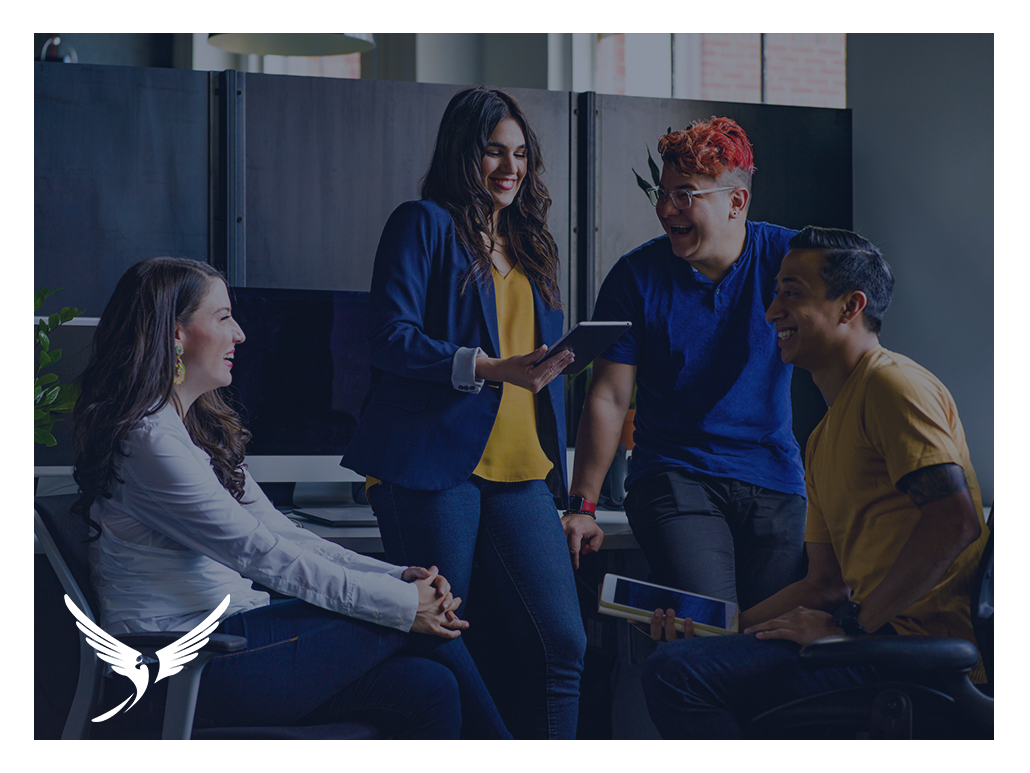 Group of people talking and laughing by their desks