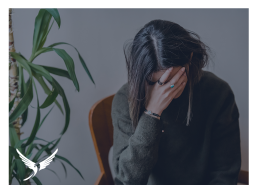 A stressed woman leaning her face into her hand