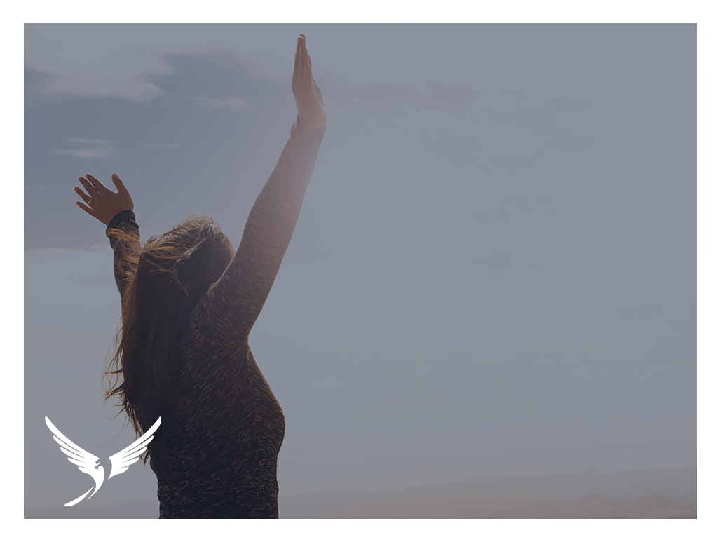 A woman with arms open towards the sky